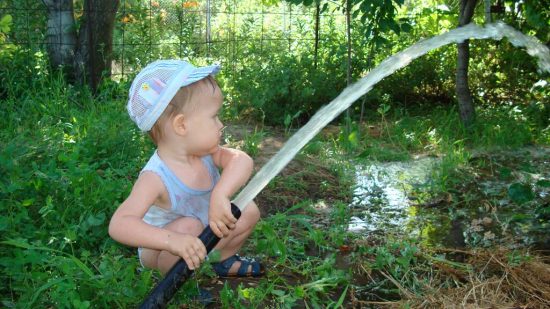 Ребёнок поливает дерево
