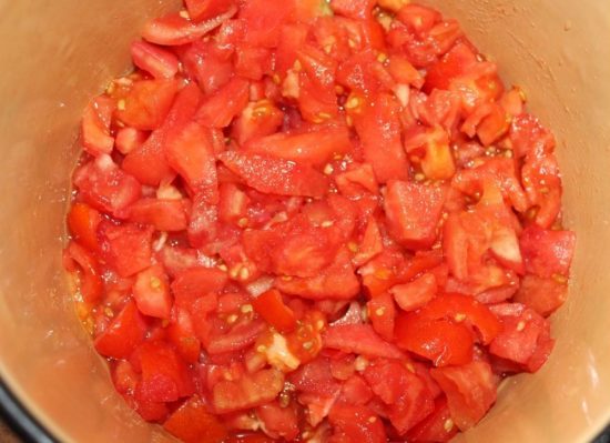 Мелко нарезанные спелые томаты в большой кастрюле